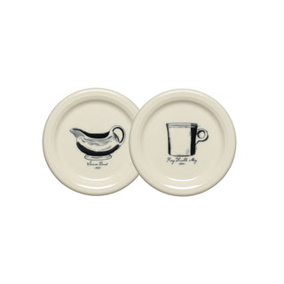 Set of two cream-colored, round coasters from Fiesta, each featuring a vintage-inspired black illustration.