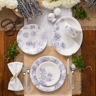A collection of blue and white floral-patterned plates arranged in a circular pattern with a light blue mug placed on top, all set against a white background.