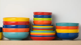 A bright assortment of bowls stacked on a shelf