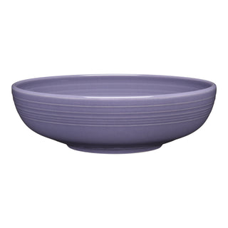 The Fiesta Lavender Bistro Coupe 10 1/2 Inch Extra Large Bowl (96 oz) is a wide, shallow ceramic serving bowl in solid lavender with subtle horizontal ridges—dishwasher safe and perfect for everyday gatherings.