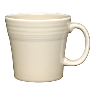 The Fiesta 15 OZ Tapered Mug by Fiesta, shown in Linen, features a handle and subtle horizontal ridges near the top. This empty mug is set against a white background.
