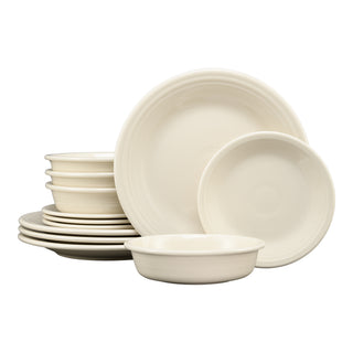The Fiesta (FTC) Classic Rim 12-Piece Dinnerware Set in Linen includes service for 4 with modern cream-colored plates and bowls, featuring a simple, classic design and smooth, slightly ridged edges.