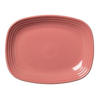 The Fiesta New Retired 12 Inch Large Rectangular Platter in Peony features a glossy pink ceramic finish, rounded corners, and a subtle concentric circle pattern at the center and rim.