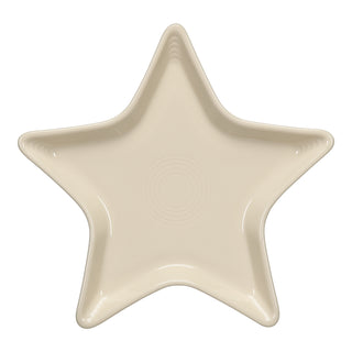 The Fiesta Star Plate in Linen features a cream hue, star shape, smooth edges, and a subtle central circular pattern—seen from above on white. Crafted from lead-safe china, it makes a charming hostess gift.