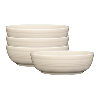 The Fiesta Linen Coupe 6 3/4 Inch Salad Bowl set includes four 24 oz cream-colored ceramic bowls with a subtle horizontal texture, adding understated elegance to any table setting.