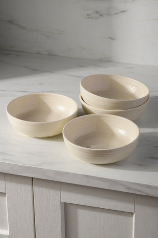 A set of four Fiesta Linen Coupe 6 3/4 Inch Salad Bowls (24 OZ) is stacked in pairs on a white marble countertop, with a white and gray marble backsplash and light cabinetry in the background.