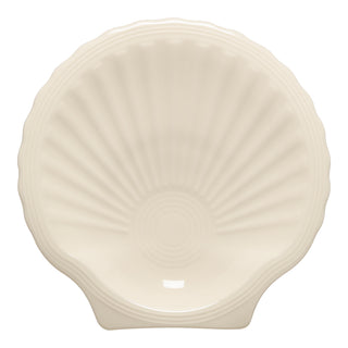 The Fiesta New Retired Shell Shaped Plate in Linen, 8 1/4 inch, features elegant fan-like ridges—perfect for adding a coastal touch to your decor or complementing any ocean-themed collection.