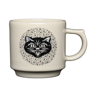The Fiesta Black Cat Linen 16 OZ Stackable Mug is a cream-colored ceramic mug made in the USA, featuring a black cat's face surrounded by small black stars on its side.