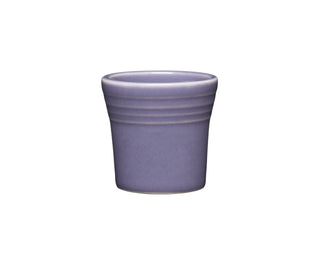 The Fiesta Lavender 1 1/2 OZ Ceramic Shot Glass, made in the USA, features a smooth purple finish and two subtle horizontal ridges near the rim, displayed on a plain white background.
