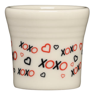 The Fiesta (FTC) Valentine 1 1/2 OZ Ceramic Shot Glass features red and black xoxo text with small hearts on white, made from lead-safe china—a charming and safe collectible for any Valentine’s Day collection.
