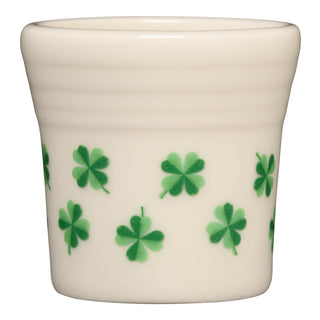 The Fiesta St. Patrick's 1 1/2 OZ Ceramic Shot Glass features a cream color with green four-leaf clover patterns, perfect for collectors and proudly made in the USA.