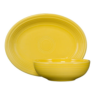 The Fiesta (FTC) New Retired 2-Piece Serve Set in Daffodil features an 11 5/8" oval platter and a 38 oz bistro bowl with subtle concentric edge patterns—a modern classic displayed against a white background.