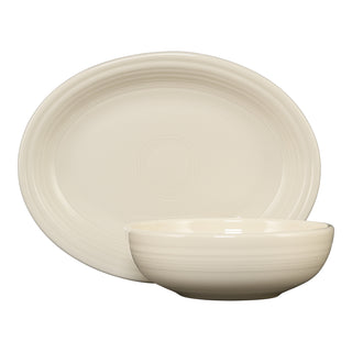 The Fiesta (FTC) 2-Piece Serve Set in Linen includes an 11 5/8 inch oval platter and a 38 oz Bistro Bowl, both cream-colored with subtle concentric ring patterns, shown against a white background.