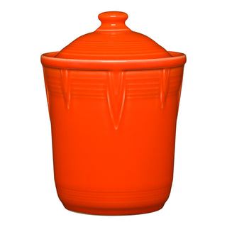 The Retired Fiesta 1 Quart Small Chevron Canister by Fiesta is a bright orange vitrified china canister with a matching lid, embossed chevron pattern, smooth glossy finish, and is lead-safe. Photographed against a white background.