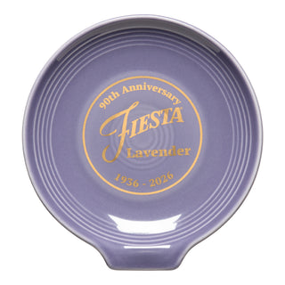 The Fiesta Lavender 90th Anniversary Extra Large Spoon Rest (7 Inch) features gold "90th Anniversary FIESTA Lavender 1936-2026" text, a ridged design, and small handle. Made in the USA, it's ideal for oversized utensils.