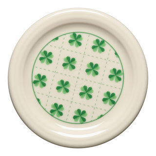 The Fiesta St. Patrick's 4 3/8 Inch Coaster and Mug Cover features a cream color with a green grid and four-leaf clovers—perfect for collectors or as festive St. Patrick’s Day decor.