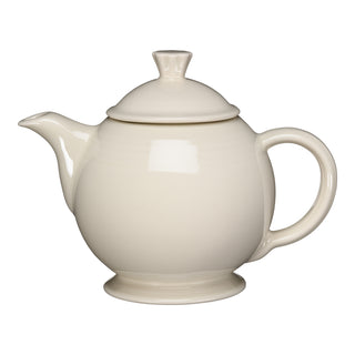 A Fiesta New Retired 44 OZ Covered Teapot in Linen, made in the USA, with a round body, curved spout, large handle, and matching lid is displayed on a white background.