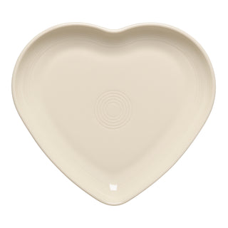 The Fiesta New Retired 9 Inch Heart Shaped Plate in Linen features a cream hue and concentric circles, ideal as a trinket dish or serving plate. Seen from above on a white background.
