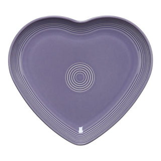 The Fiesta Lavender 9 Inch Heart Shaped Plate features a purple ceramic finish with a Lavender glaze and raised concentric rings, shown from above on a white background—an elegant piece for any collectible dinnerware set.