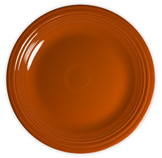A round, orange ceramic plate with concentric circular ridges along the rim, viewed from above on a white background.
