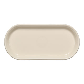 The Fiesta 11 7/8 Inch Oblong Serving Platter in Linen features a smooth, cream-toned finish with a subtle circular pattern and is microwave safe—combining style and practicality for everyday use.