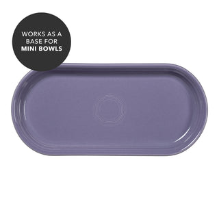 A Lavender 11 7/8 Inch Oblong Serving Platter by Fiesta features a circular ridge pattern at its center. A dark circle in the corner highlights that it works as a base for mini bowls. The empty ceramic serving tray has an oblong shape and is shown against a white background.