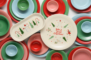 Add a festive touch to your holiday gatherings with the Fiesta Jolly Christmas Classic 11 7/8-Inch Oblong Serving Platter, featuring cheerful red, green, pink, and blue tableware encircling two white platters decorated with snowmen, trees, candy canes, and “Have a Jolly Christmas!”—perfect for serving up seasonal treats at your next celebration.