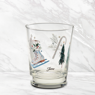 Add holiday spirit to your table with the Fiesta Jolly Christmas 15 oz. Tapered Double Old Fashion glasses from Moderne Glass. This set of four features a clear, tapered design adorned with festive prints—ice skates, candy canes, Christmas trees, greenery, and red berries—set against a white marble background. Proudly made in the USA, these charming pieces are perfect for celebrating the season.