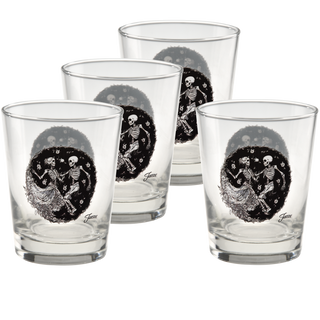 A set of four Moderne Glass Fiesta Skeleton Duet 15 oz. Tapered Double Old Fashion glasses, each featuring identical black and white designs of a skeleton and a woman dancing in a circular pattern. Made in the USA, the glasses are arranged in two rows on a white background.