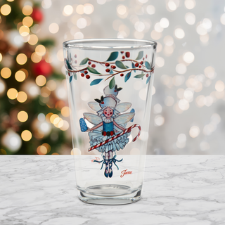 Add a festive touch to your Christmas table with the Nutcracker Sugar Plum Fairy 16 oz. Cooler Glasses from Moderne Glass—a set of four beautifully decorated glasses featuring holly along the rim and a whimsical illustration of the Sugar Plum Fairy holding a candy cane, pictured on a marble surface with blurred holiday lights and a Christmas tree in the background.