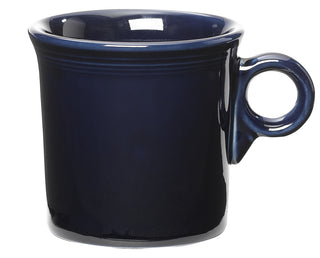 The Fiesta Retired Classic Ring Handle 10 1/4 OZ Mug in Cobalt features a glossy dark blue finish, large round handle, and slightly flared rim. Made in the USA, it offers timeless style for your kitchen. Displayed on a white background.