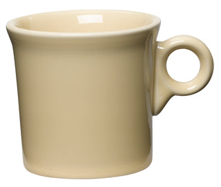 The Fiesta Retired Classic Ring Handle 10 1/4 OZ Mug in ivory features a simple, classic design with a glossy finish. Made in the USA from lead-safe china, this ceramic mug is shown against a white background.