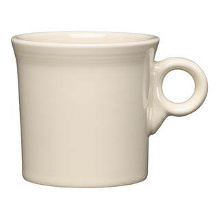 The Fiesta Classic Ring Handle 10 1/4 OZ Mug in Linen features a simple, classic design with a round handle and slightly flared rim. Crafted from lead-safe china, this cream-colored mug is shown against a white background.