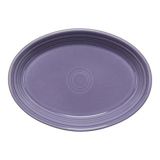 Oval-shaped, purple ceramic plate with a glossy finish and concentric circle design in the center, viewed from above on a white background.