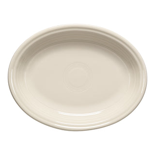 The Fiesta 11 5/8 inch Medium Oval Serving Platter in Linen is an oval, cream-colored ceramic platter with a subtle embossed pattern—ideal for family-style meals and proudly made in the USA.