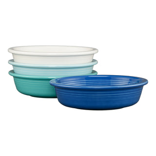 The Fiesta Mixed Coastal Blues Classic Rim 6 7/8 Inch Cereal Bowl set includes four 19 oz microwave-safe bowls in white, light blue, teal, and dark blue, featuring a simple ribbed design inspired by coastal hues.