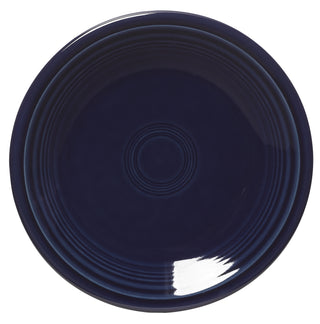 The Fiesta Retired Classic Rim 7 1/4 Inch Salad Plate in cobalt blue features a glossy finish and concentric circle patterns, is lead-safe, dishwasher safe, and shown from above.