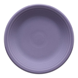 The Fiesta Lavender Classic Rim 7 1/4 Inch Salad Plate, made in the USA from lead-safe china, has a round shape, subtle concentric ridges near the rim, a smooth glossy finish, and displays its solid lavender hue when viewed from above.