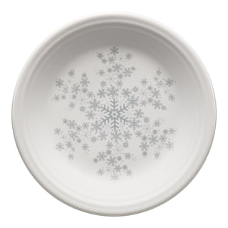 The Fiesta (FTC) White Snowflake Classic Rim 7 1/4 Inch Salad Plate, made in the USA, features a large snowflake with smaller ones in light gray—ideal for festive dinnerware settings.