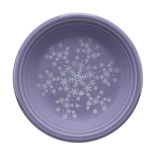 The Fiesta Lavender Snowflakes Classic Rim 7 1/4 Inch Salad Plate displays white snowflakes on a round purple surface—festive, USA-made dinnerware seen from above.