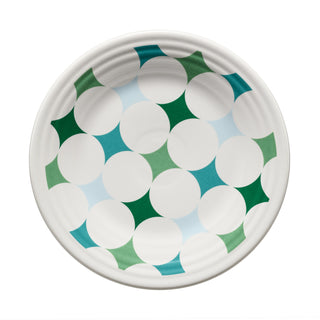 The Fiesta Aegean Kaleido Circles Classic Rim 9 Inch Luncheon Plate is a white plate adorned with an eye-catching geometric pattern of overlapping green, teal, and blue star shapes, creating a vibrant circular design on a crisp white background. Crafted from dishwasher-safe china by Fiesta, this elegant luncheon plate beautifully blends artistic flair with practical everyday use.