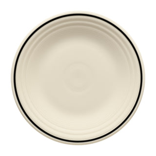 The Fiesta Black Band Classic Rim 9 Inch Luncheon Plate features a round, cream design with concentric ridges and a slim black line near the rim. Shown from above on a white background. Made from Lead-Safe China for safety.