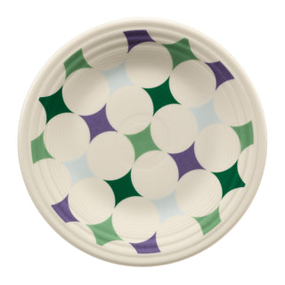 The Fiesta Lavender Bloom Kaleido Circles Classic Rim 9 Inch Luncheon Plate showcases a round white surface adorned with a captivating geometric pattern of green, light blue, and purple star shapes interlaced with white circles, all arranged in symmetrical harmony.