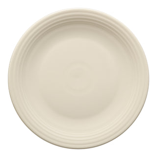 The Fiesta Chop Plate 11 3/4 Inch in Linen features a round, cream-colored ceramic design with a smooth surface and subtle ridges near the rim, viewed from above on a white background. Made with lead-safe china.