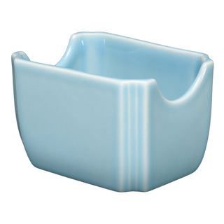 The Fiesta Sky 3 1/2 Inch Sugar Packet Holder features a light blue ceramic design with a rectangular shape, curved top edges, glossy finish, and two vertical ridges on one side. Made in the USA from dishwasher-safe china.