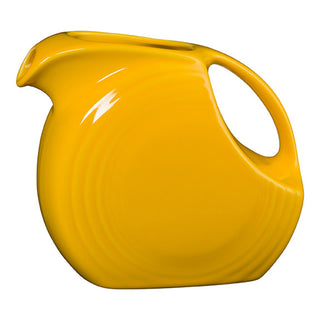 The Fiesta New Retired 67 OZ Large Disk Pitcher in daffodil features a rounded body, wide handle, small spout, and glossy lead-safe china for a vintage look inspired by the iconic classic style.