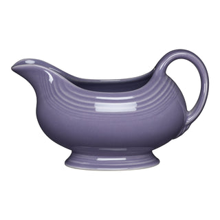 A purple ceramic gravy boat with a curved spout and handle, set against a white background.