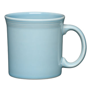 A light blue ceramic mug with a large handle, featuring subtle horizontal lines near the rim, set against a white background.