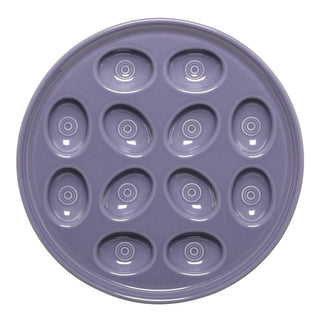 The Fiesta Lavender Round Egg Serving Platter (11 1/4") features twelve oval indentations with concentric circles, perfect for deviled eggs or appetizers. Crafted from ceramic and made in the USA.