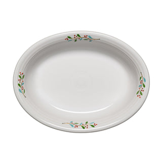 The Fiesta Retired Holly Berry Christmas Oval Baker, 10 1/4 inch and 40 oz, features a white ceramic design with green leaves and red berries along the rim—an elegant, oven-safe dish ideal for serving or baking.